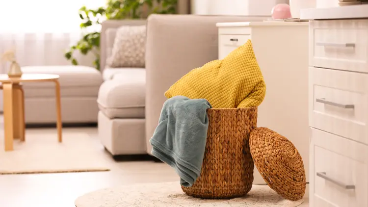 blog-storage a wooden basket with a green blanket and yellow pillow in it