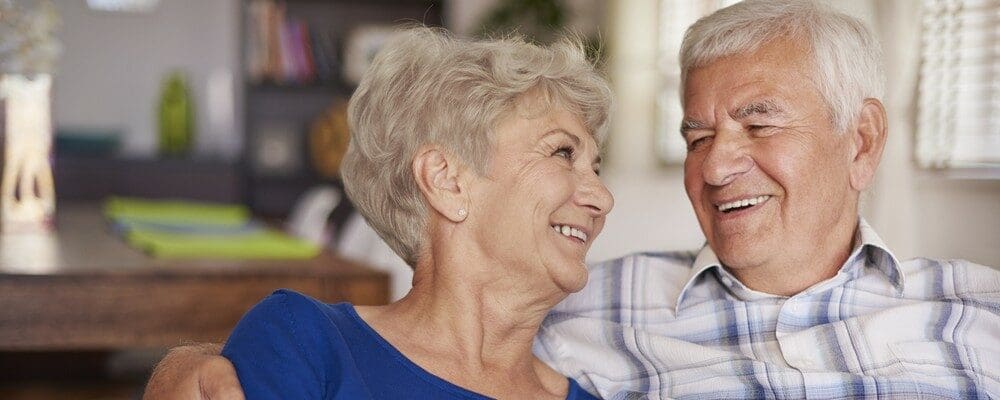 shutterstock_287991707 Happy senior couple sitting on sofa