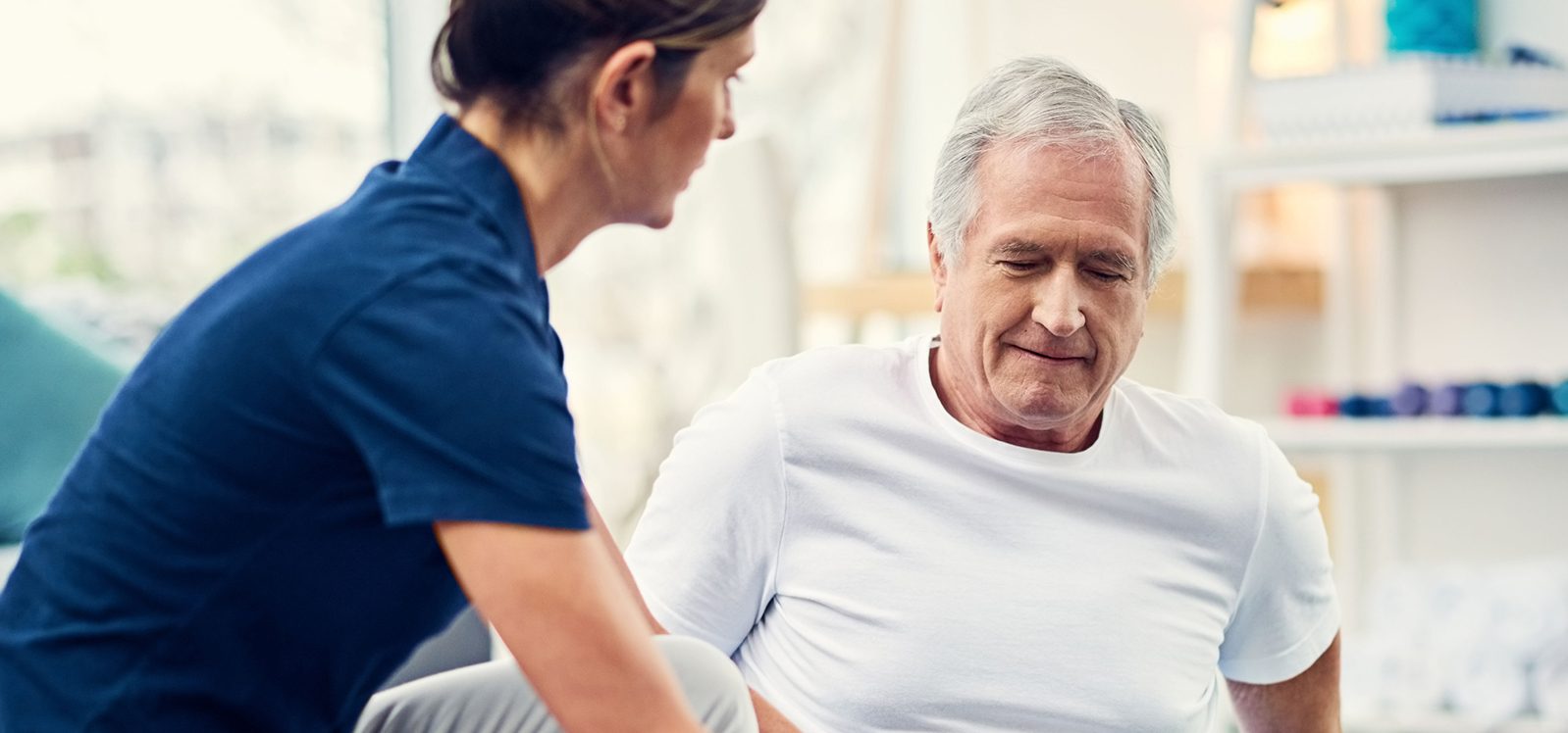 young female physiotherapist working with a senior male patient young female physiotherapist working with a senior male patient