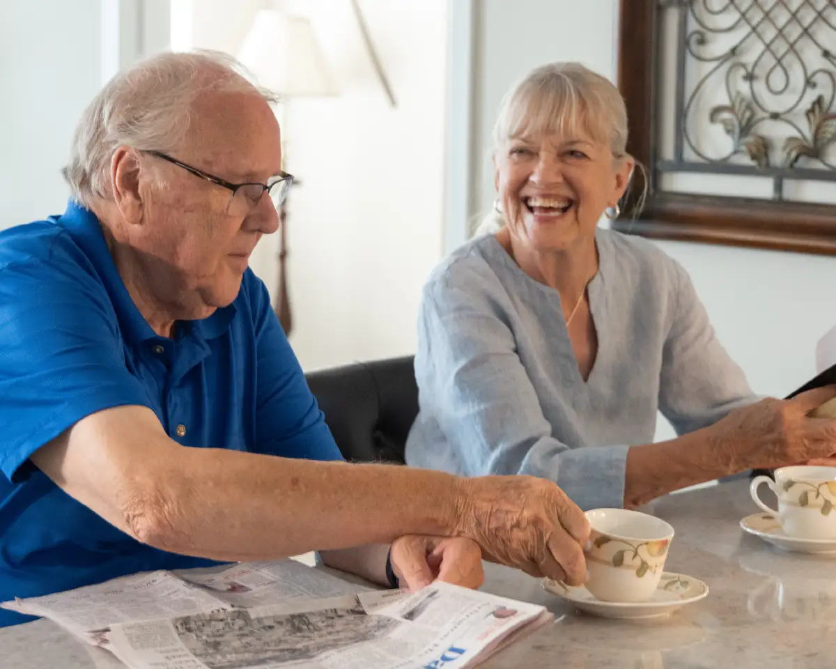 Senior couple eating breakfast and reading the newspaper