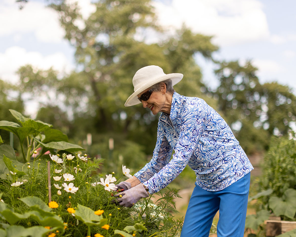Resident woman gardening outdoors at Lake Forest Place