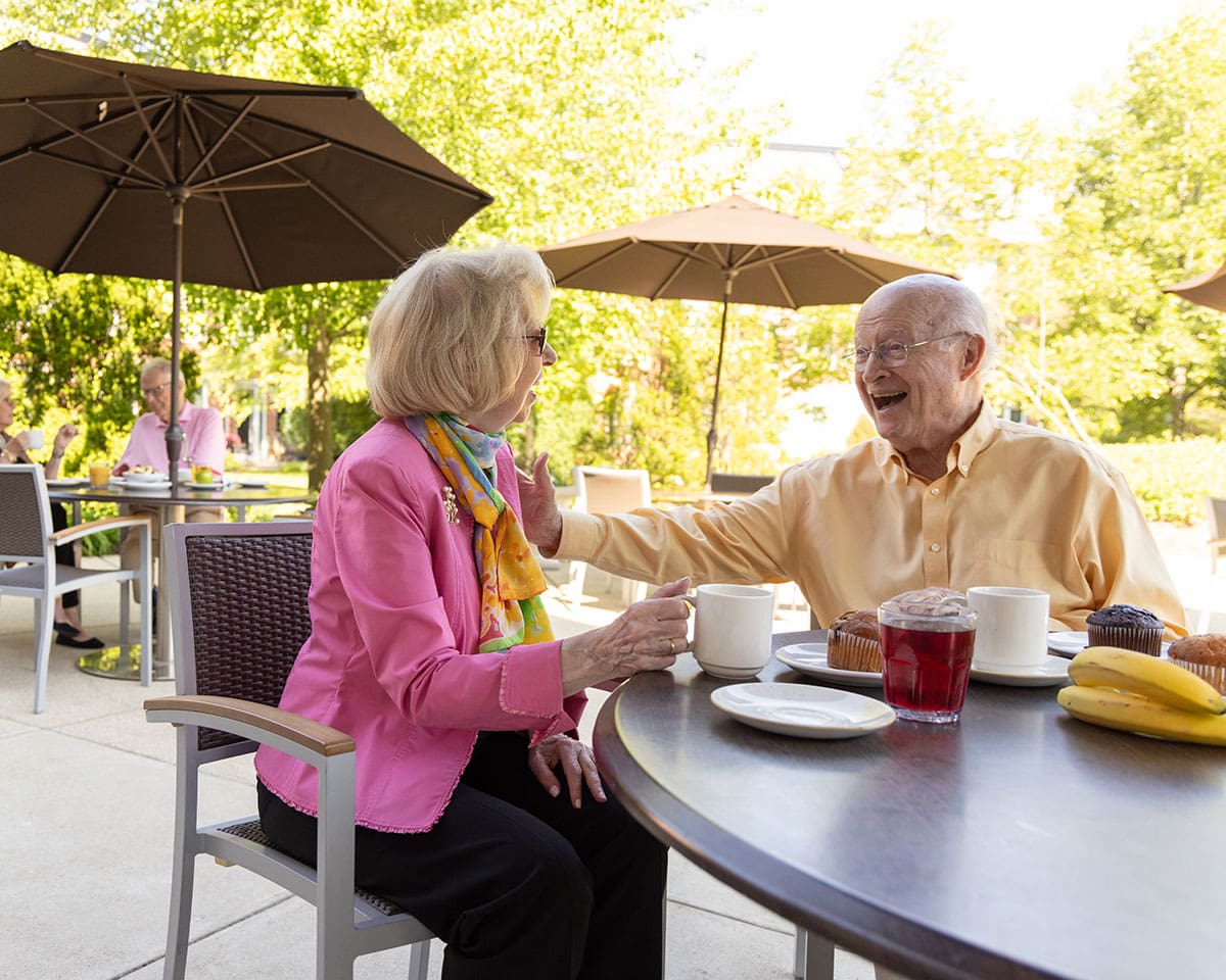 Senior couple dining outdoors at Lake Forest Place