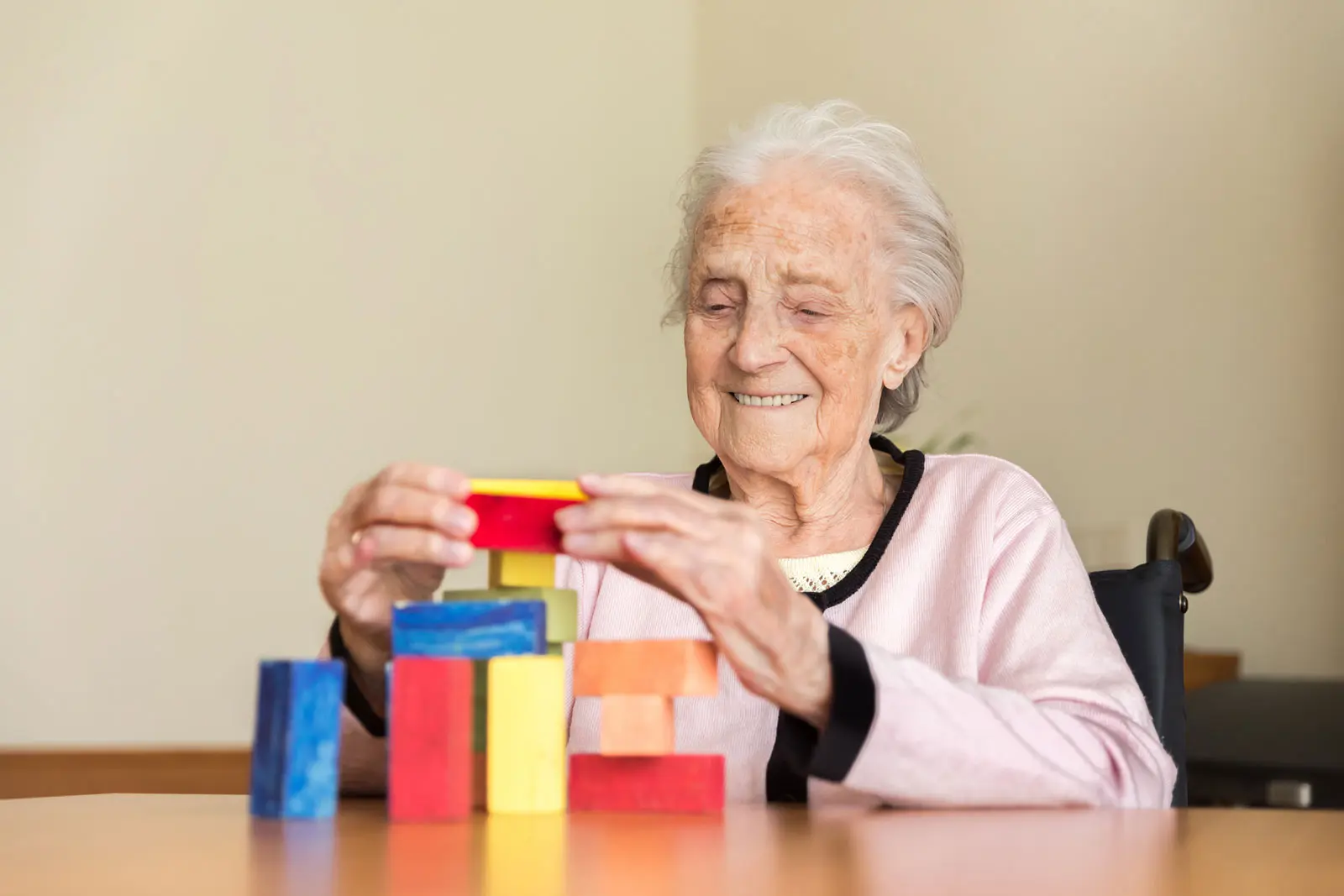 Senior woman stacking colored blocks