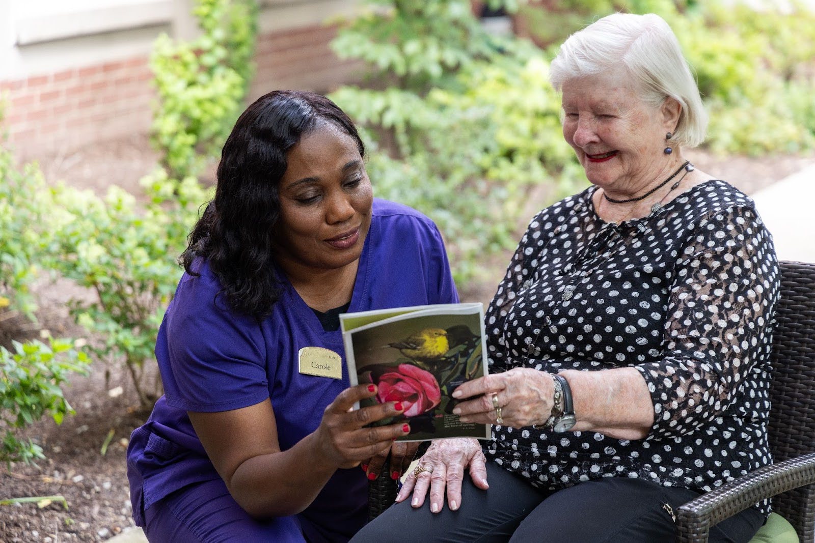 PHLF February 2024 Blog Featured Image Resident at Lake Forest Place reading outdoors with her caregiver
