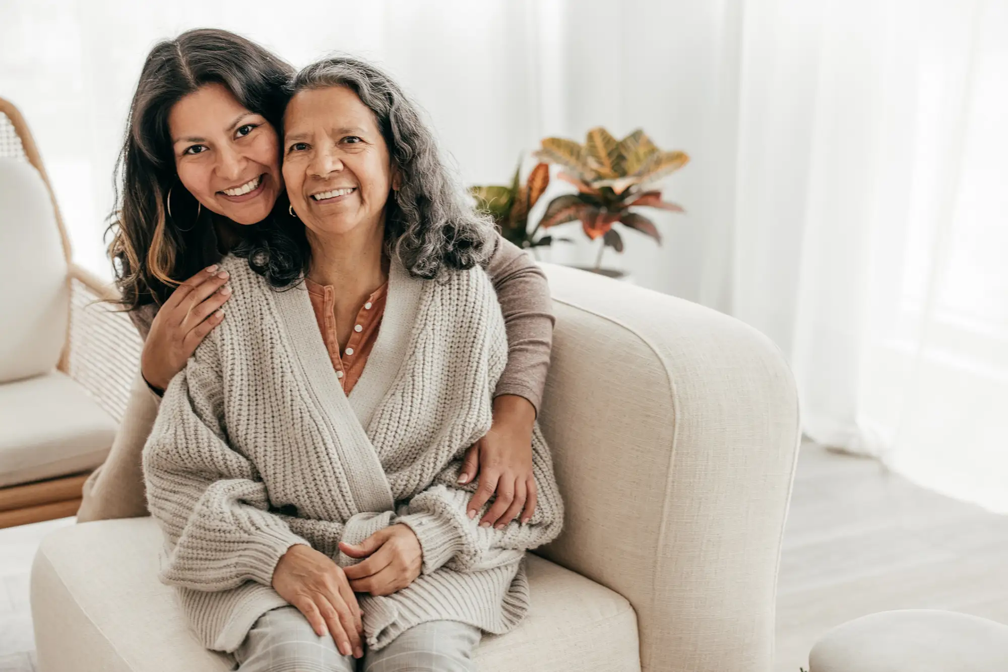 PHLF November Blog Featured Image Daughter hugging her senior mother on a sofa