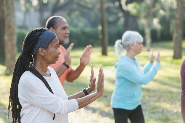 PHMA 70618 SEO Blog Update_ Tai Chi Benefits a group of seniors practicing Tai Chi outside on a sunny day