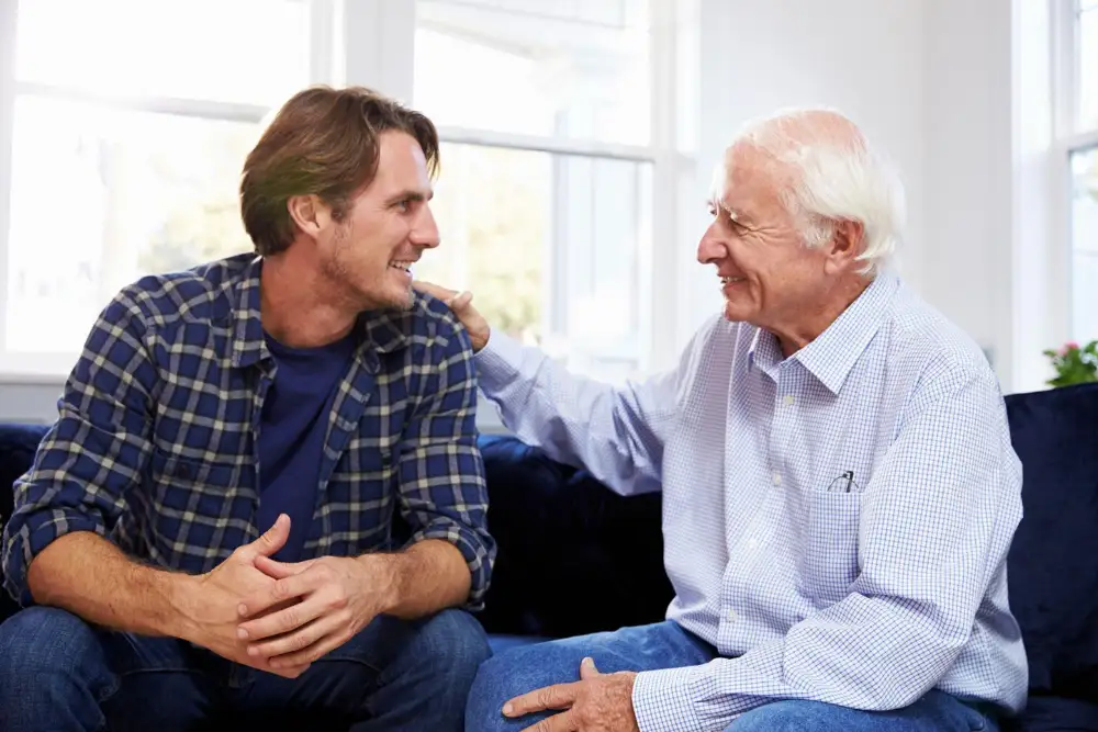a man talking with his senior parent in the living room