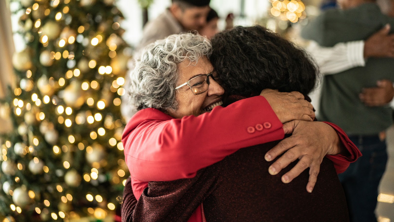 Senior woman hugging her daughter on christmas at home
