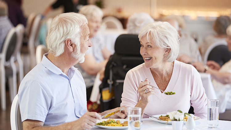 a senior couple enjoying a meal at their senior living community