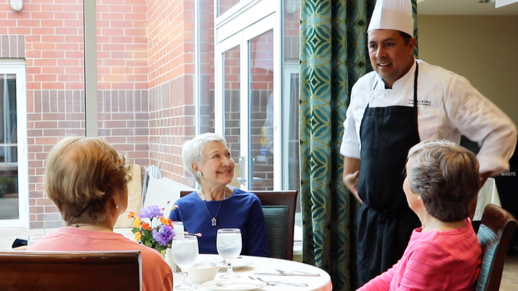 blog-look-at-dining a group of senior women talking to the chef at their senior living community