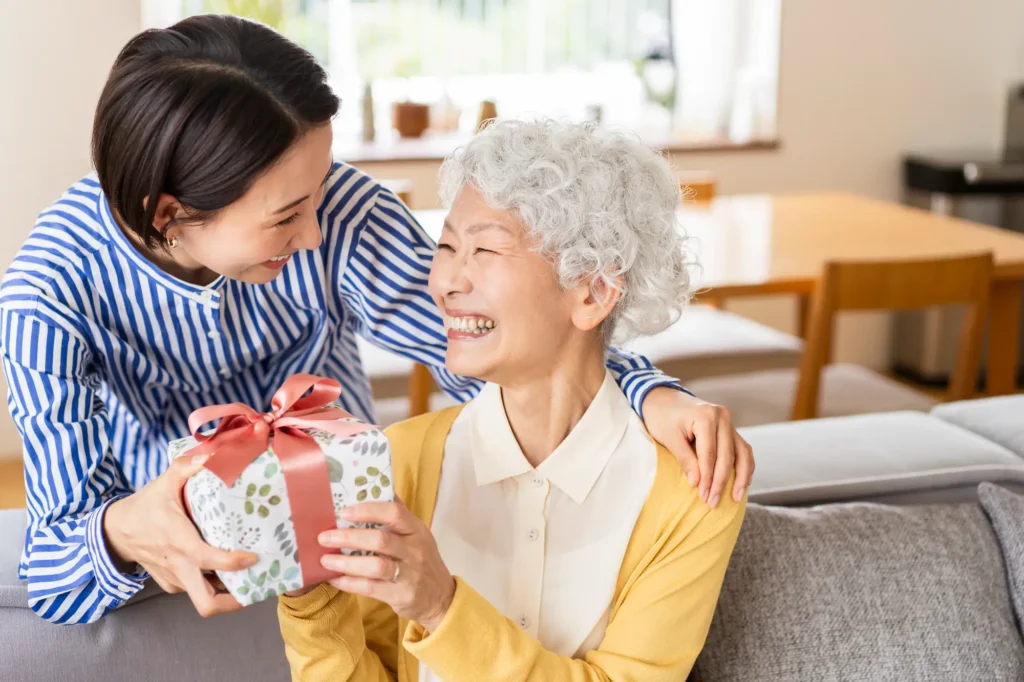 woman giving her senior mother a gift