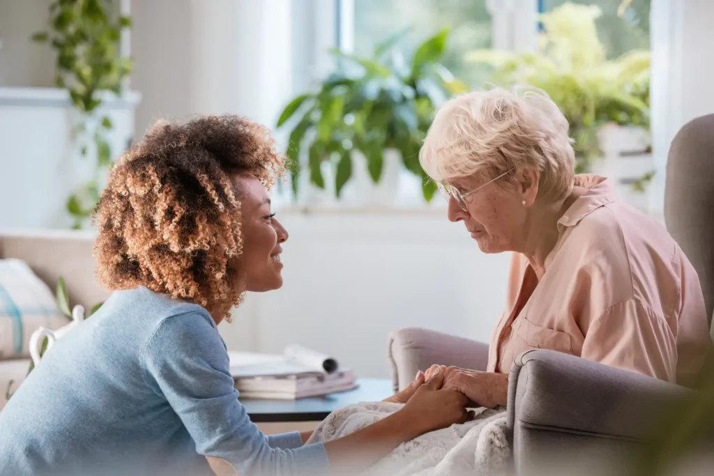 Cheerful caregiver supporting a senior woman
