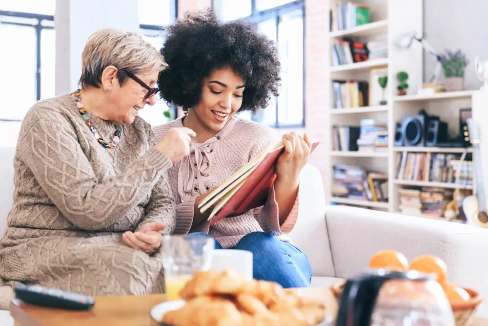 a woman and her senior mother looking at an old photo album together
