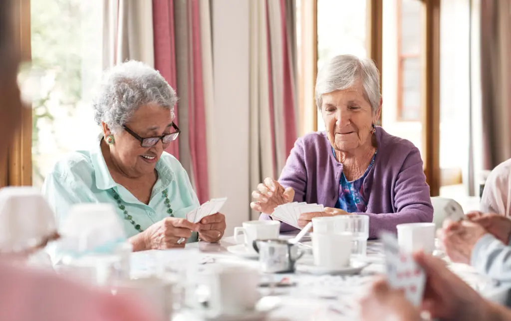 senior women playing cards at table