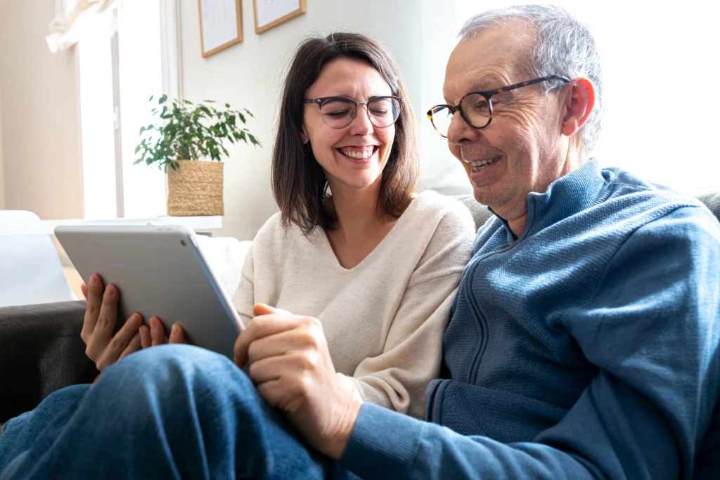 adult woman and senior man looking at tablet together 