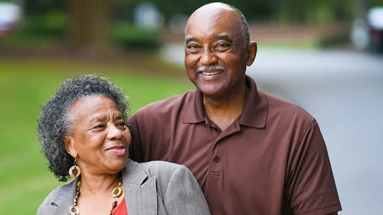 A senior couple smiling and posing for a photo, independent living vs. assisted living Lake Forest Place, IL
