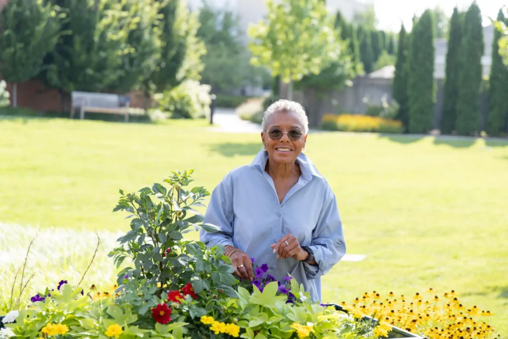 senior woman at The moorings by raised garden bed