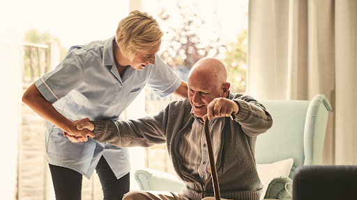 senior man getting help with one of the ADLs, mobility senior man in assisted living with caregiver