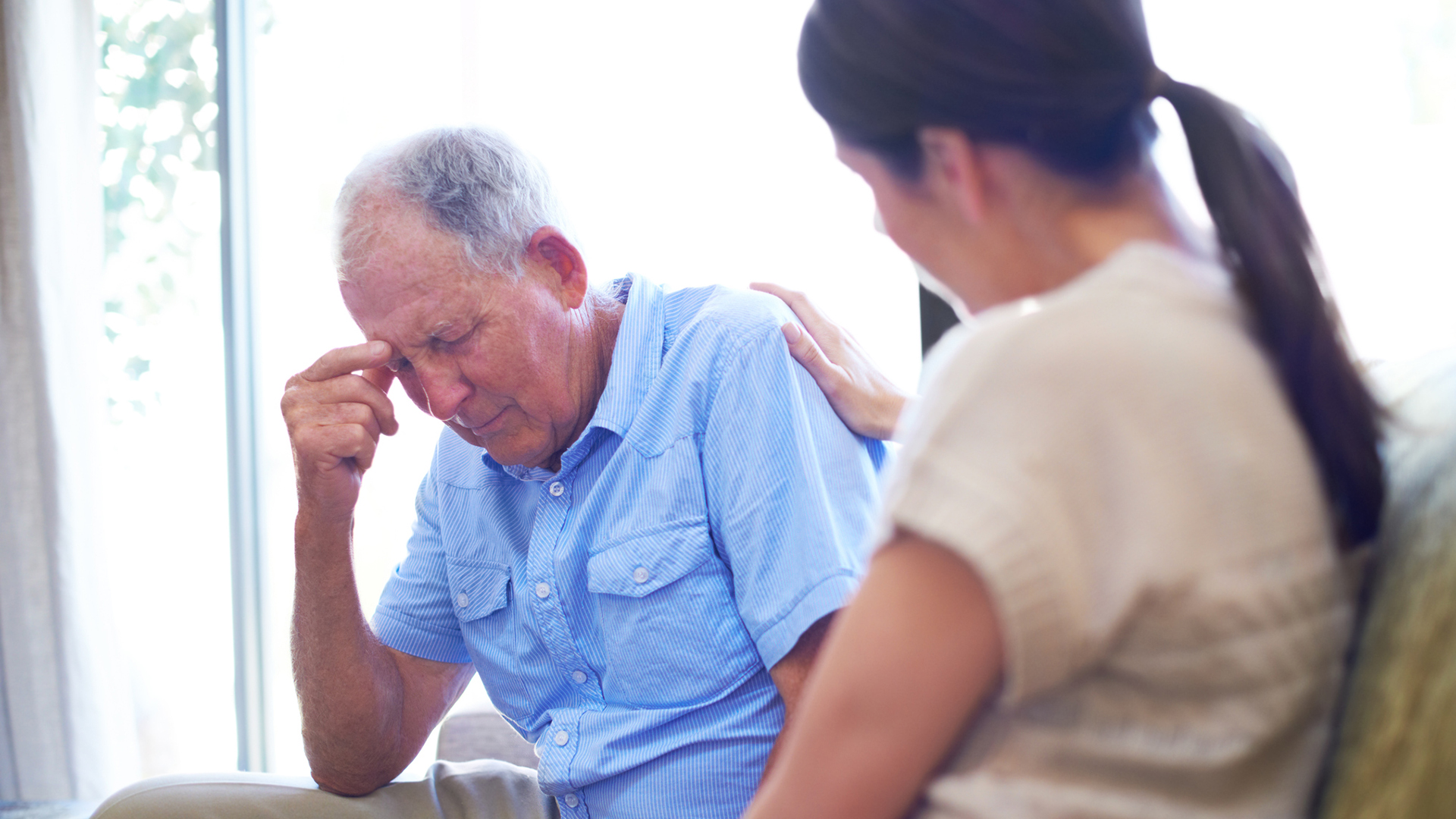 senior man looking tired while talking with his daughter