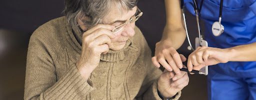senior woman with anogognosia dementia being helped by her caregiver senior woman with anogognosia dementia being helped by her caregiver