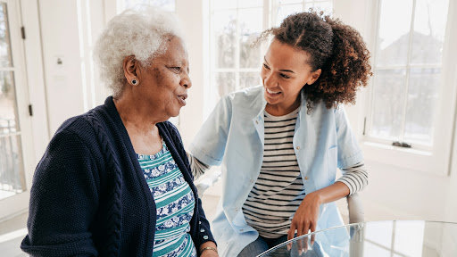 A healthcare service provider talking to a senior woman. senior woman with dementia sitting with her loved one
