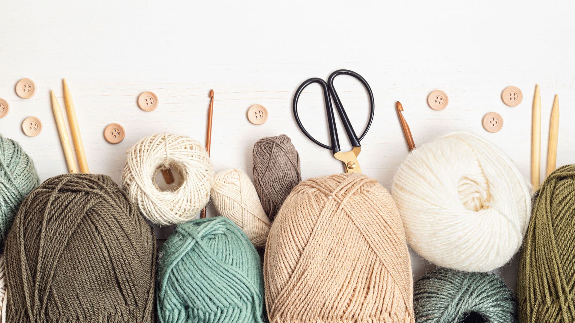 skeins of yarn and knitting needles on a table skeins of yarn and knitting needles on a table