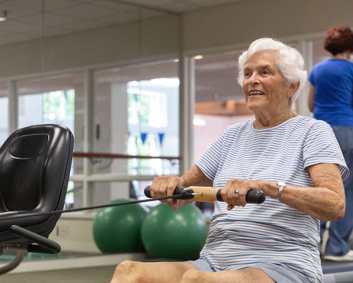 Senior woman working out with a trainer in the fitness center at Westminster Place