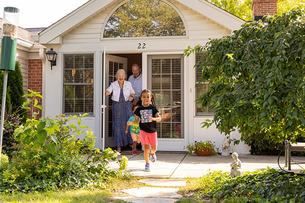 Resident couple and their grandchildren playing outside their residence at Westminster Place